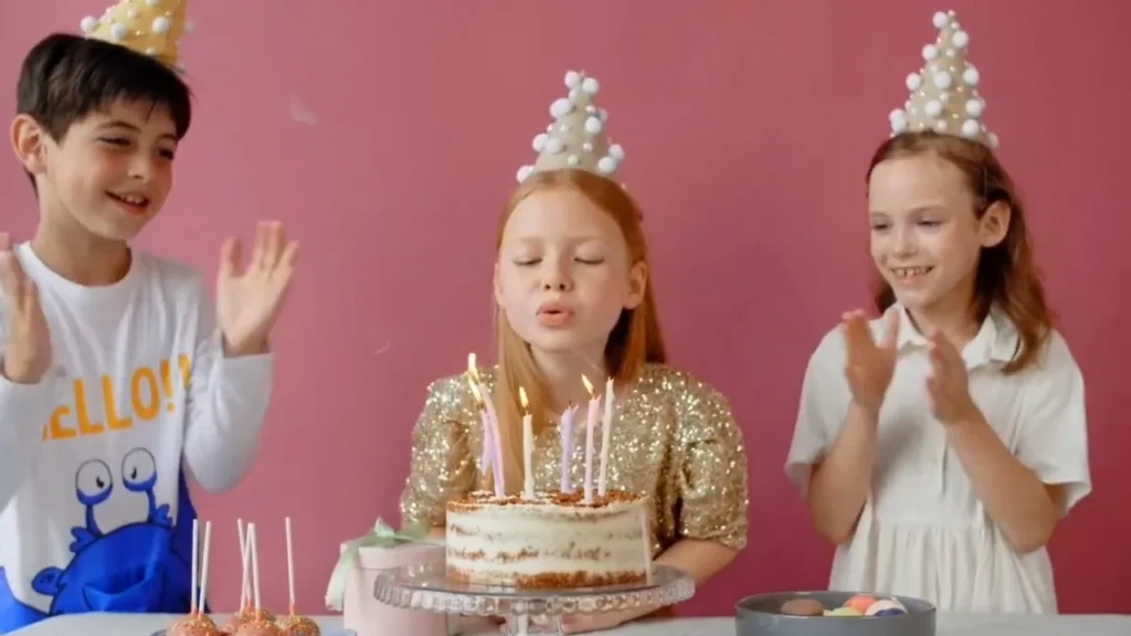 Children celebrating birthday with cake and candles.